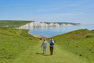 2 men standing on green grass field near body of water during daytime by Marc Najera courtesy of Unsplash.