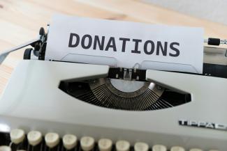 a close up of a typewriter with a donation sign on it by Markus Winkler courtesy of Unsplash.