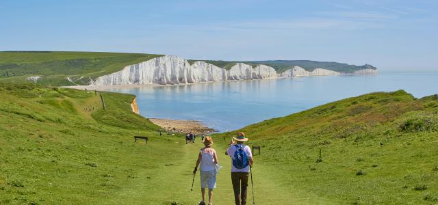 2 men standing on green grass field near body of water during daytime by Marc Najera courtesy of Unsplash.